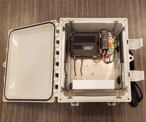 Open NEMA enclosure containing a Digi cellular router, PULS power supply, and white module.