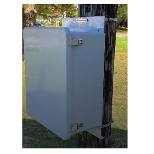 A light gray equipment enclosure secured to a wooden utility pole with mounting brackets.