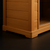 Close-up view of the ZenTherm™ Solo Infrared Sauna base, showing the smooth Hemlock wood construction and rounded edge resting on a matte black luxury floor.