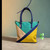 PAULIE SIGNATURE SUN & SEA TOTE BAG.

Carry Color. Carry Confidence.
Make a statement wherever you go with the Paulie Signature Sun & Sea Tote Bag  a bold,
artistic bag created for women who love color, individuality, and effortless style.
Its beautiful geometric color-block design combines turquoise, natural beige, vibrant yellow, and deep navy blue,
creating a distinctive look that easily elevates both casual and dressed-up outfits.

The spacious tote style design makes it a practical choice for work, shopping, meetings, travel, or everyday use,
while the long handles provide comfortable carrying.

Why You’ll Love It
Unique color-block design
Spacious and practical
Stylish statement piece
Comfortable double handles
Easy to pair with many outfits
A distinctive accessory for women who love to stand out


PAULIE ORGANIC CARE
Style with personality. Carry it with confidence.


