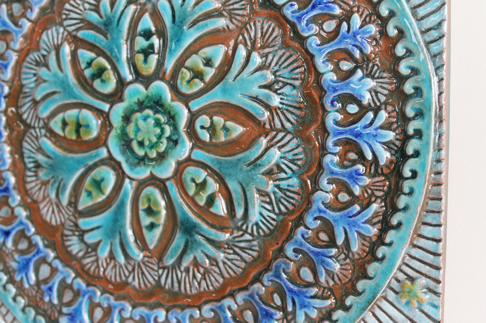 Turquoise handmade tile with decorative relief. Large decorative tile with Suzani design.