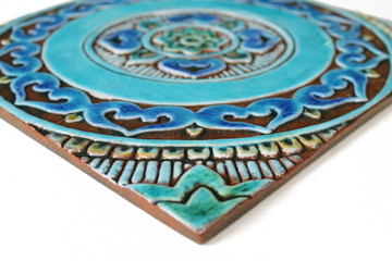 Turquoise handmade tile with decorative relief. Large decorative tile with mandala design.