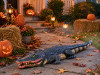 Alligator Halloween yard prop displayed on a front walkway with pumpkins, hay bales, and fall decor