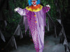 creepy circus clown prop standing in haunted house setting