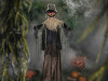 Life-size scarecrow Halloween prop standing in spooky yard