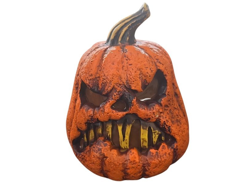 Light up evil pumpkin Halloween decoration with glowing face on spooky rustic tabletop