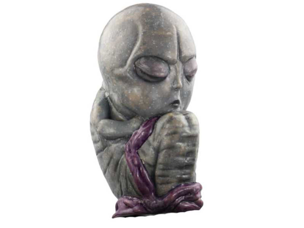 Alien Baby Doll Prop holding a purple blanket