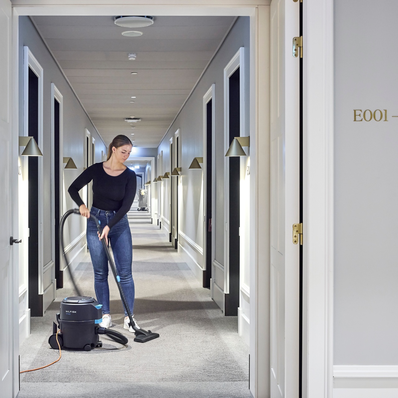 Nilfisk canister vacuum cleaning a hotel hallway