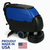 A commercial-grade walk-behind auto scrubber with a durable black and blue body, optimized with “Proudly Made in USA” text and an American flag in the top right corner. This machine represents industrial floor cleaning power and reliability.