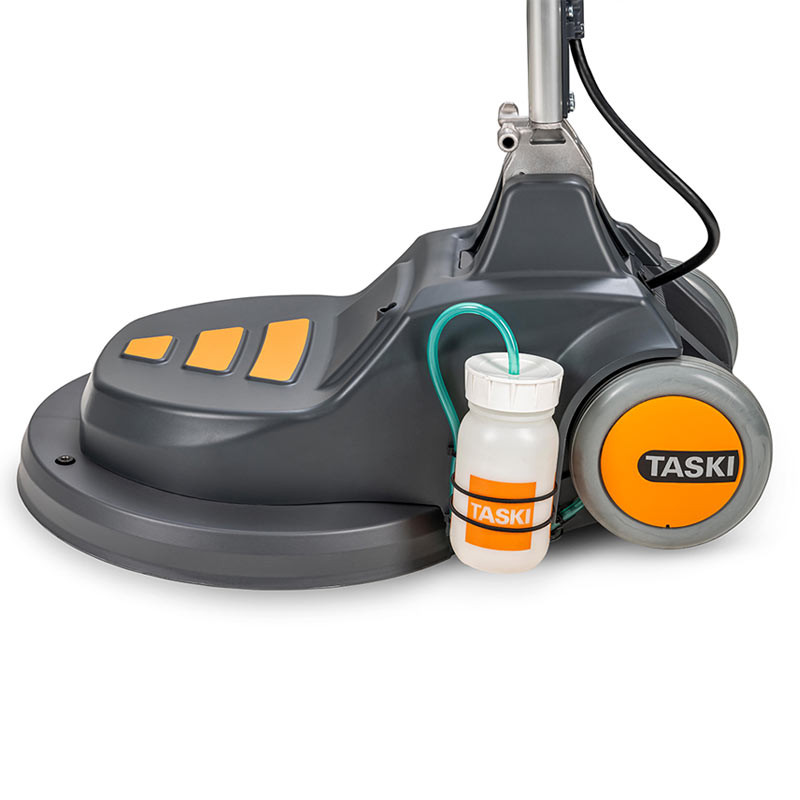 Side view of the TASKI FLEXX base showing the attached solution dispensing system, rugged wheel design, and cord management.