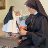 A Sister MICM works on the Original Saint Statues.