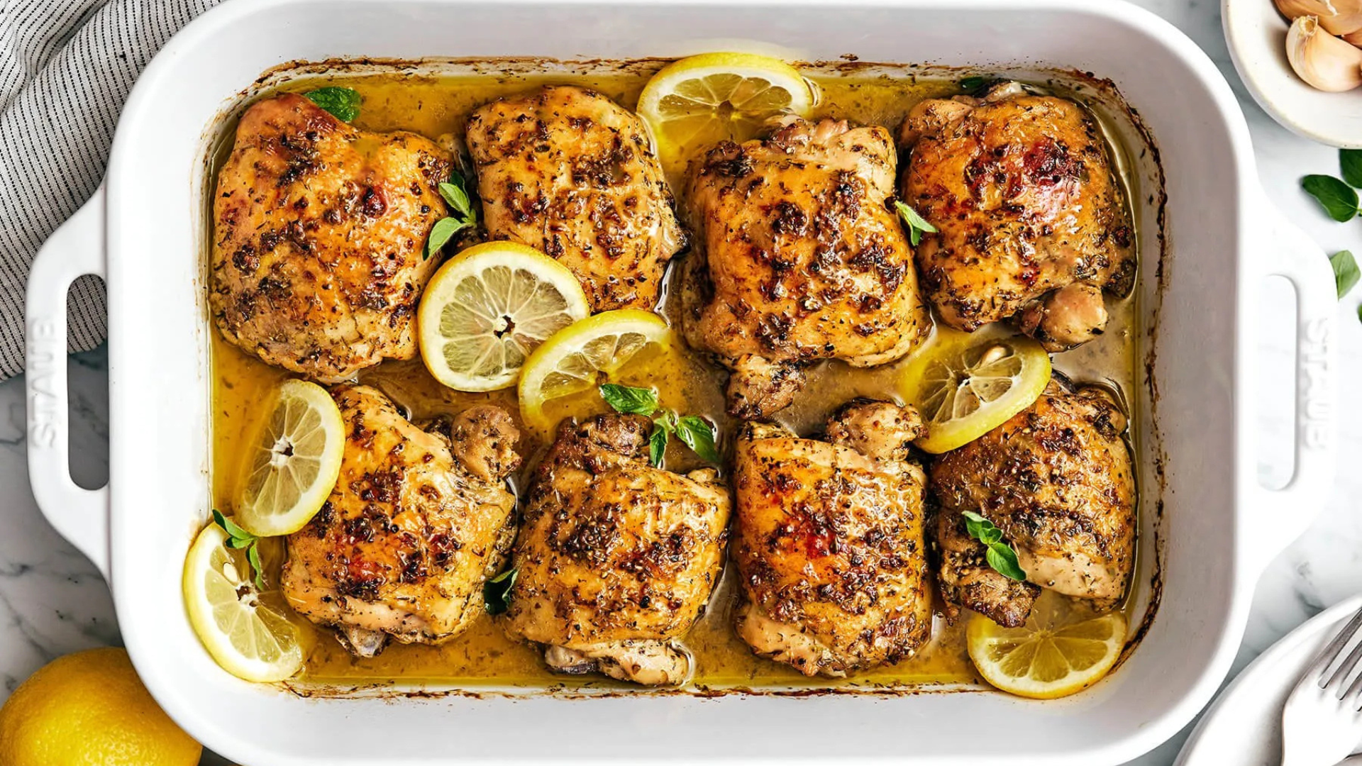Lemon herb roasted chicken thighs served in a baking dish