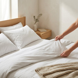 white-180-thread-count-bedding-on-bed-hands-demonstrating-soft-fabric-feel
