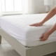 white-quilted-mattress-protector-9-inch-deep-lifestyle-hand-demonstrating-quilted-fabric-on-bed