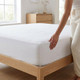 white-68-pick-polycotton-fitted-sheet-4-foot-bed-lifestyle-hand-demonstrating-fabric-fit-on-bed