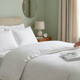 white-800-thread-count-premium-cotton-rich-2cm-sateen-stripe-duvet-cover-set-on-bed-hand-demonstrating-luxurious-sateen-finish-sheen-bedroom-lifestyle
