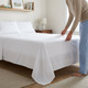 white-budget-range-flat-sheet-on-bed-hand-demonstrating-fabric-drape-bedroom-lifestyle