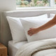 white-200-thread-count-100-percent-cotton-percale-pillowcases-on-bed-hand-demonstrating-crisp-smooth-percale-weave-premium-cotton-texture