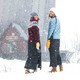 Two women wearing Skhoop Original Insulated Skirts outdoors in winter, après-ski style