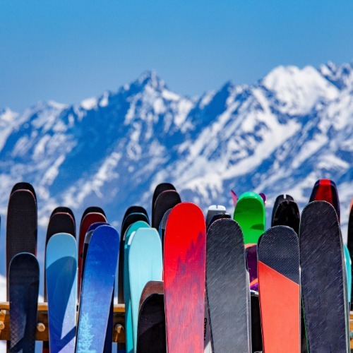 skis on a ski rack in front of a mountain 