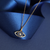 Gold Evil Eye Sapphire CZ Pendant displayed on navy blue ribbon – lifestyle jewellery photo