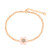 Gold bracelet with a single daisy motif featuring soft pink pearl petals and a crystal-encrusted center on an adjustable chain.