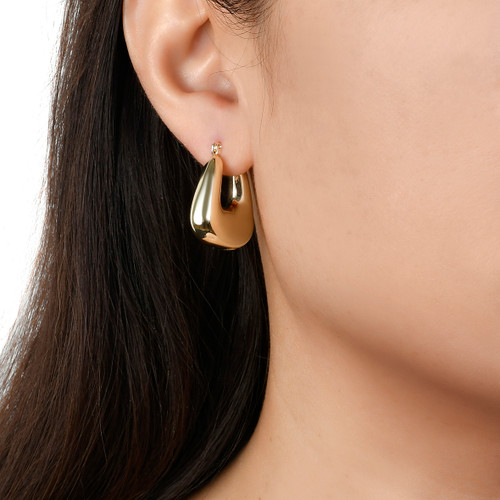 model wearing gold squared hoop earrings