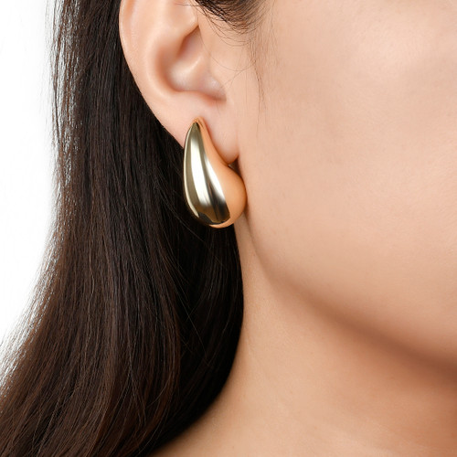 model wearing gold teardrop drop earrings