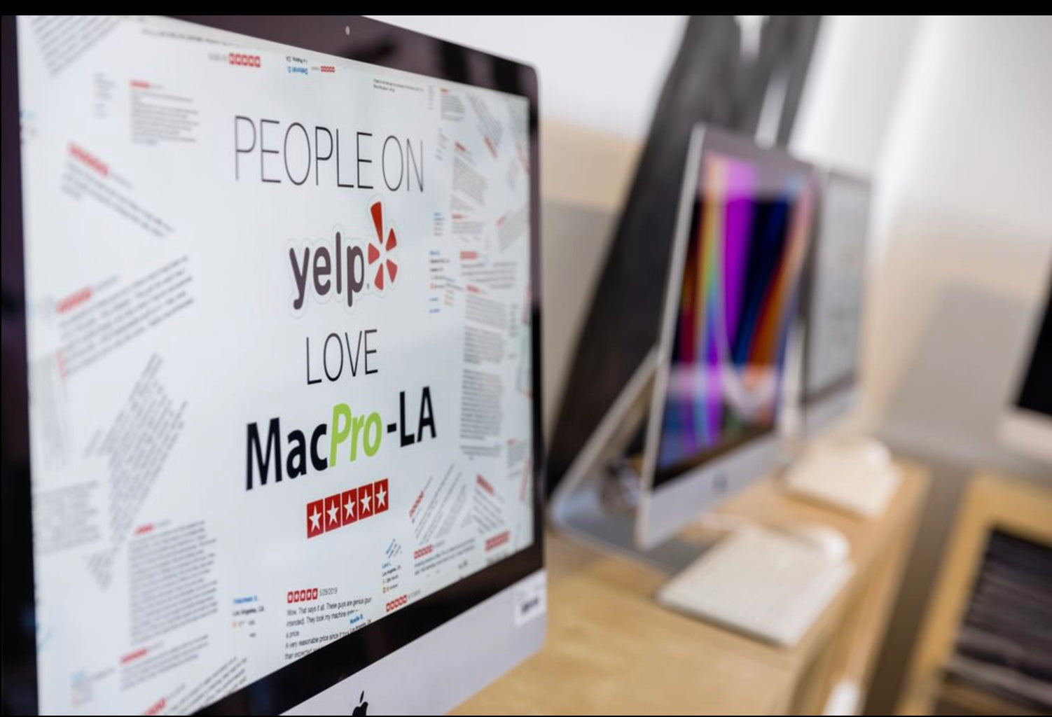 iMac display at MacPro-LA showing five-star Yelp reviews from customers