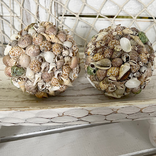 This handcrafted mixed sea shell ball is a unique 12cm table decoration, blending natural shells in soft, earthy tones. Perfect for coastal, boho, or tropical home decor