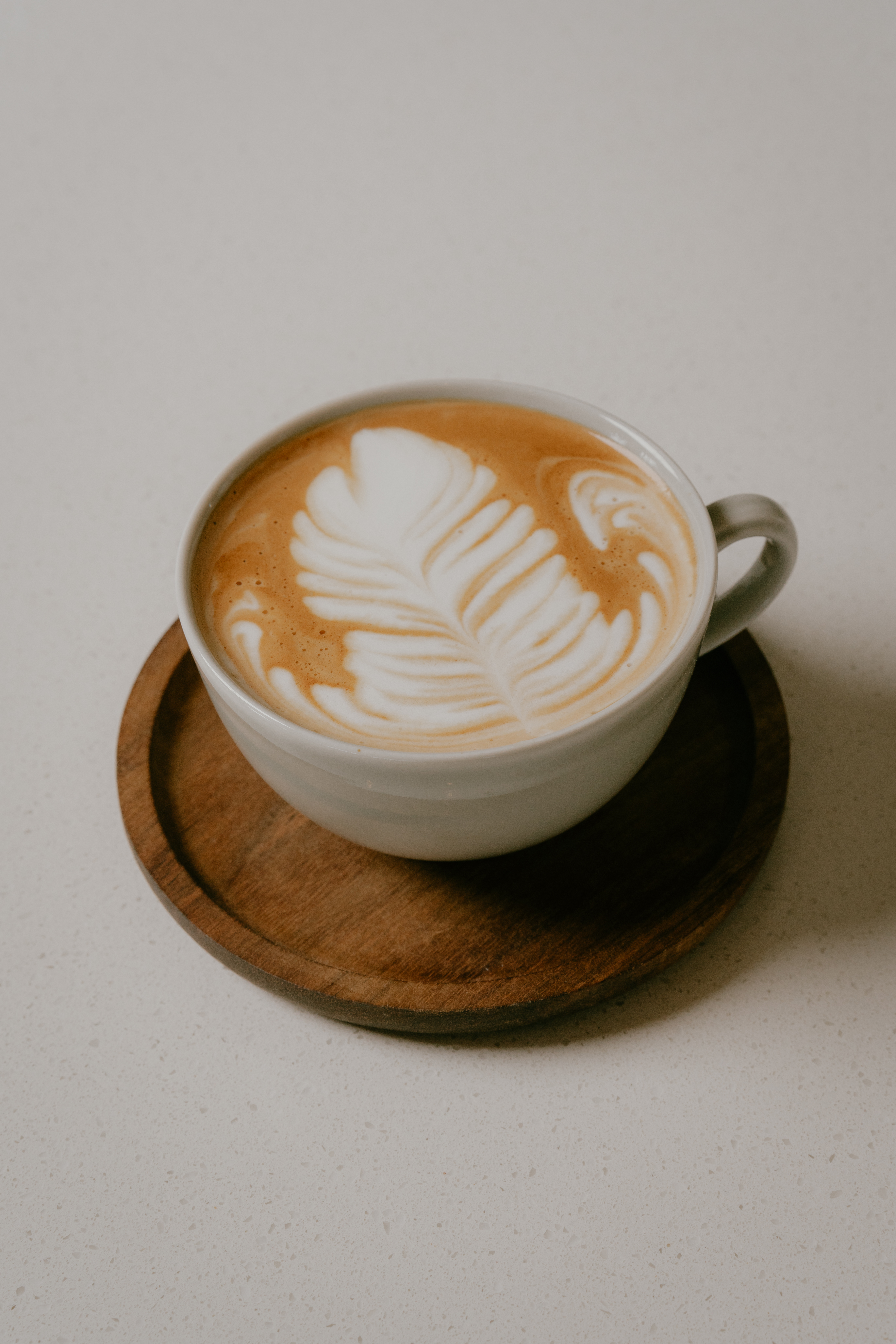 Two cups of 100% Kona coffee on a sunlit café table