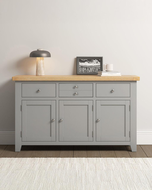 Hampton Pebble Grey 3 Door 3 Drawer Sideboard HG400-405-050, modern grey sideboard with wooden top, featuring three doors and three drawers, in a minimalist living room setting.