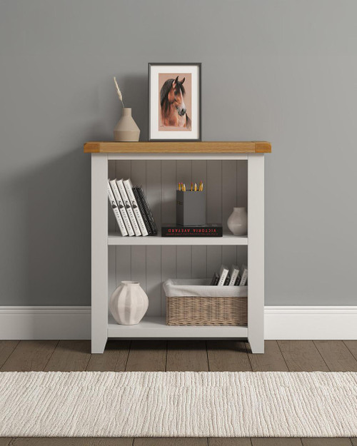 Hampton Ivory Low Bookcase HI300-306-054, a white wooden bookcase with a natural wood top, decorated with books, a basket, and vases in a room. Hampton Ivory Low Bookcase HI300-306-054, a white wooden bookcase with a natural wood top, decorated with books, a basket, and vases in a room.