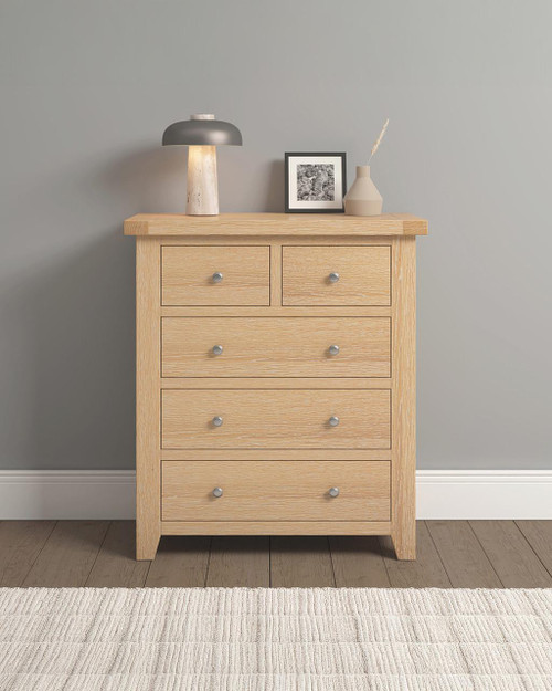 Hampton Oak 3+2 Drawer Chest HO100-102-221, wooden bedroom storage unit with five drawers and round metal knobs, placed against a light grey wall with decorative items on top. Hampton Oak 3+2 Drawer Chest HO100-102-221, wooden bedroom storage unit with five drawers and round metal knobs, placed against a light grey wall with decorative items on top.