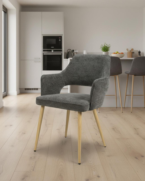 Stanley Dark Grey Dining Chair, modern upholstered chair with wooden legs and curved backrest in a contemporary kitchen setting.