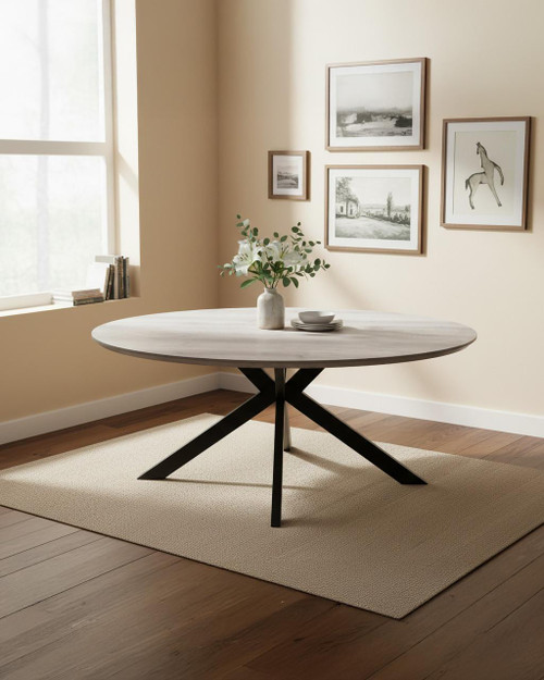Roma 180cm Grey Oval Table, modern dining table with a light grey wooden top and black angular metal legs in a minimalist dining room with framed artwork and a vase with flowers.