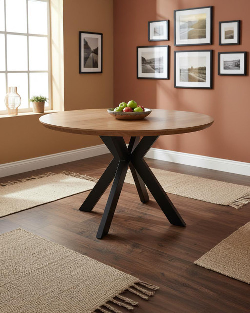 Hamilton Rustic Oak 120cm Round Table, wooden dining table with a rustic oak finish and modern black legs, located in a cozy dining room with framed wall art and natural light.