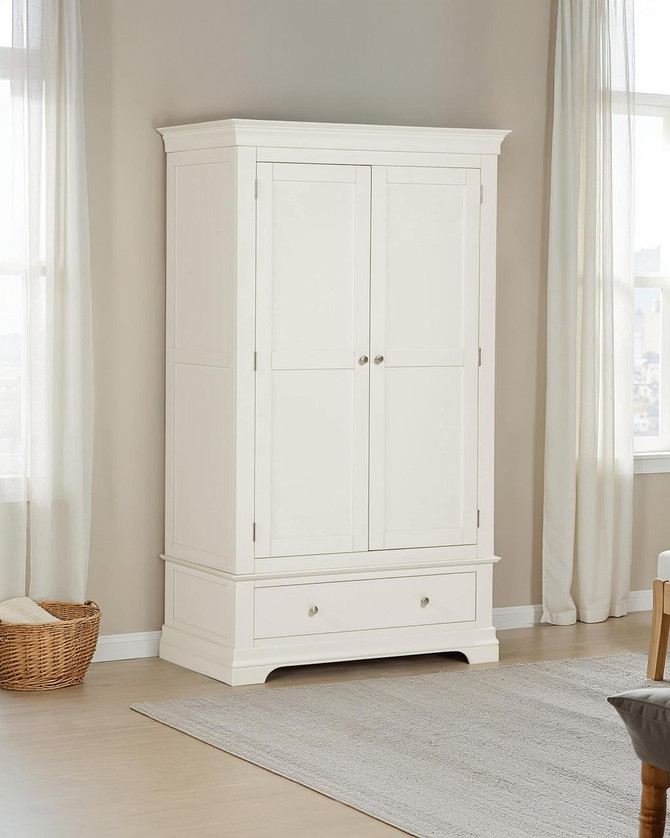 Vermont 2 Door Wardrobe, white wooden wardrobe with two doors and a bottom drawer, in a bright room with natural light and cream-colored curtains.