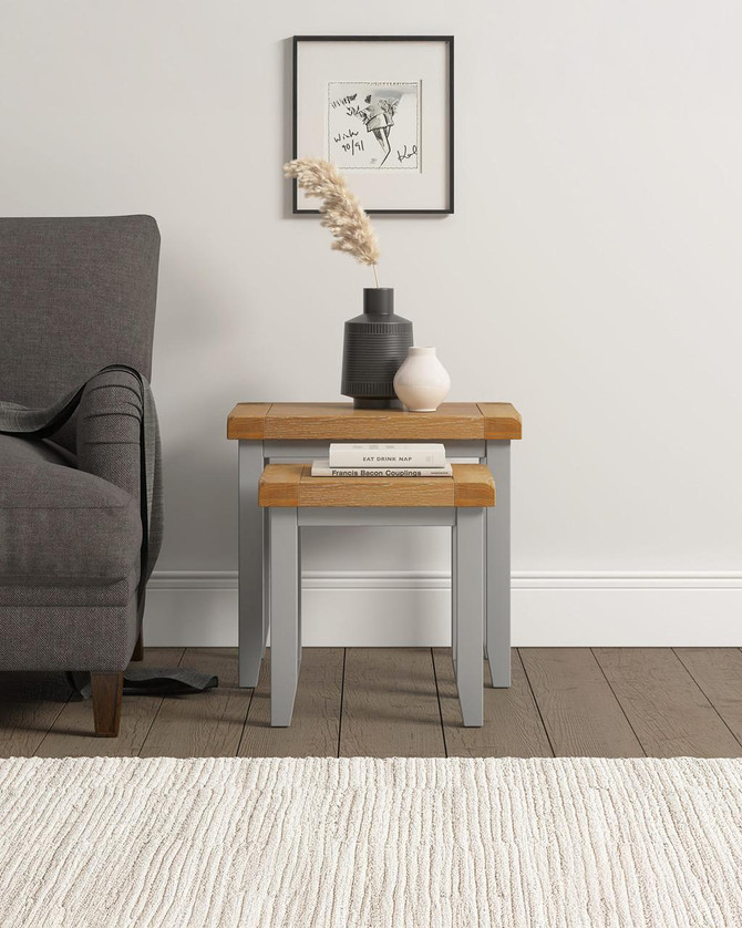 Hampton Pebble Grey Nest of 2 Tables HG300-303-041, a modern nested side table set with a grey and natural wood finish, placed beside a grey sofa in a contemporary living room.