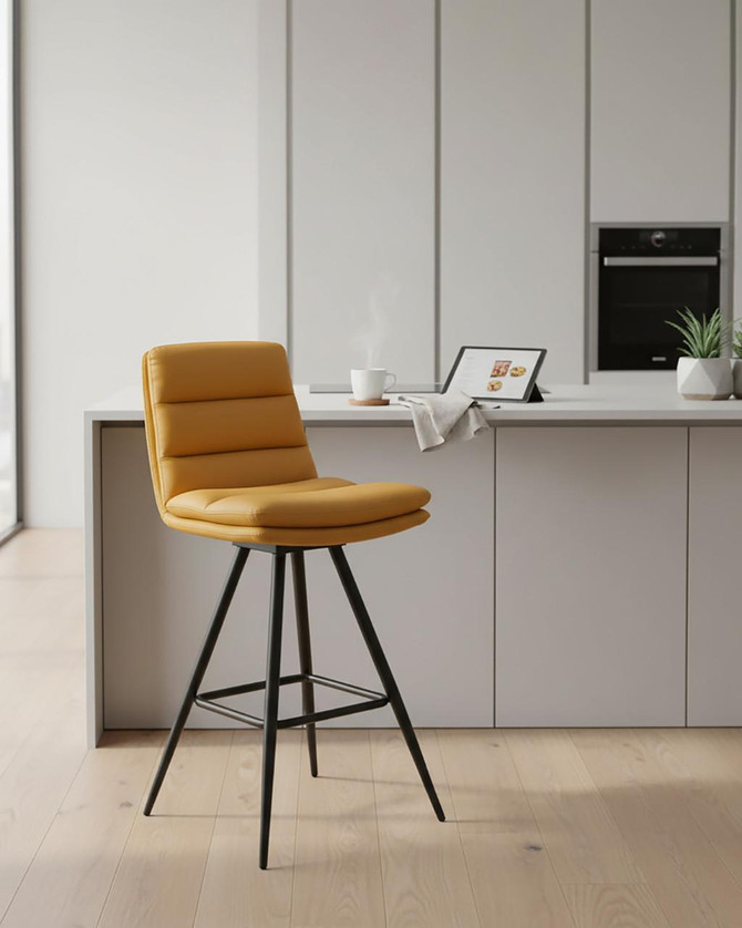 Hamilton Swivel Bar Chair In Ochre, pair of modern yellow swivel bar chairs with cushioned seats and backrests, black metal legs, set in a sleek contemporary kitchen.