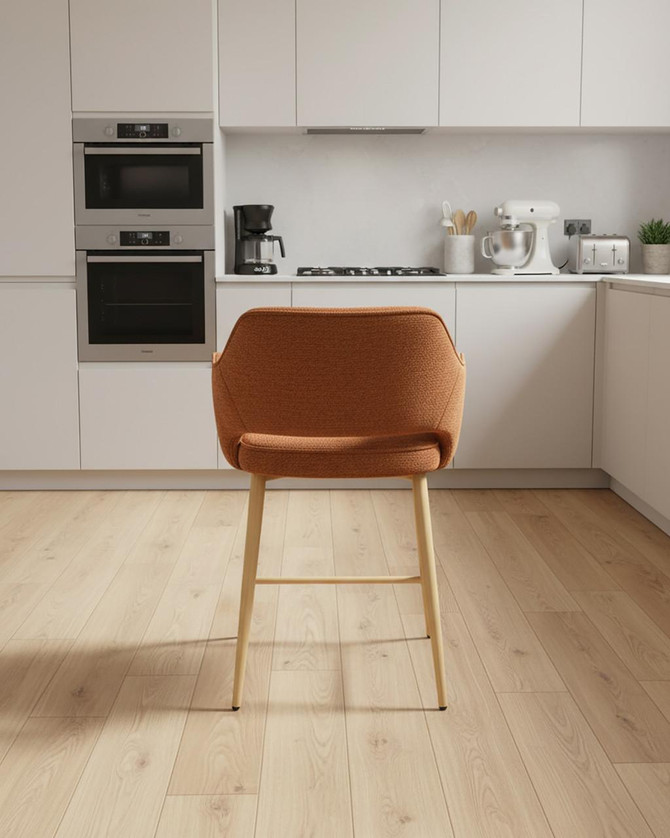 Stanley Rust Coloured Kitchen Counter Chair, orange fabric upholstered seat with wooden legs in a modern kitchen setting. Stanley Rust Coloured Kitchen Counter Chair, orange fabric upholstered seat with wooden legs in a modern kitchen setting.