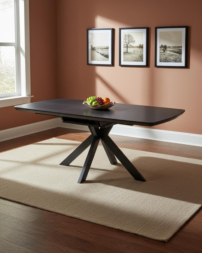 Hamilton Black Ash Extending Table 140cm - 180cm Table, a modern black extending dining table in a well-lit room with framed pictures and a bowl of fruit.