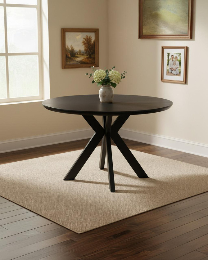 Hamilton 120cm Black Ash Round Table, modern black ash wood dining table with a smooth round surface and distinctive angular legs in a contemporary interior setting.