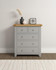 Hampton Pebble Grey 3+2 Drawer Chest HG100-102-222, a grey wooden bedroom chest with five drawers and a natural wooden top, decorated with modern vases and a framed photograph.