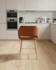 Stanley Rust Coloured Kitchen Counter Chair, orange fabric upholstered seat with wooden legs in a modern kitchen setting. Stanley Rust Coloured Kitchen Counter Chair, orange fabric upholstered seat with wooden legs in a modern kitchen setting.