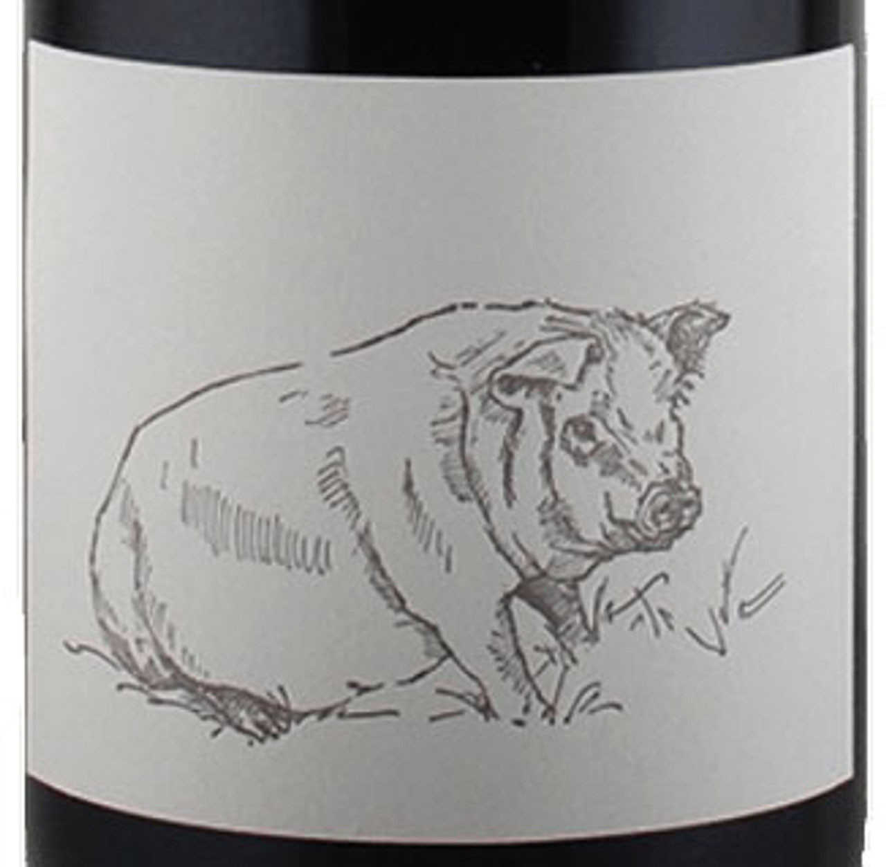 Close-up of a wine bottle with a label featuring a sketched pig resting in a grassy field.