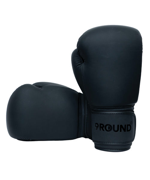 Two matte black boxing gloves with a 9Round logo on the cuff