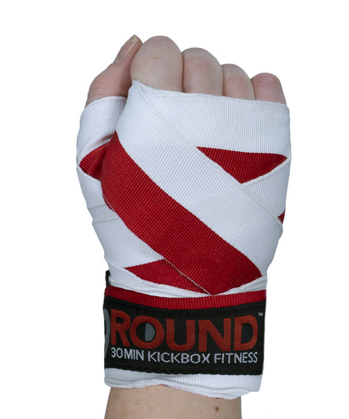 A hand held in the air in a fist with the back of the hand facing you and wearing a red and white striped boxing hand wrap A hand held in the air in a fist with the back of the hand facing you and wearing a red and white striped boxing hand wrap