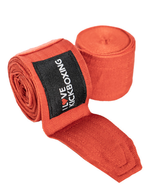Two rolled red hand wraps with a black label that reads I Love Kickboxing in white and red text.