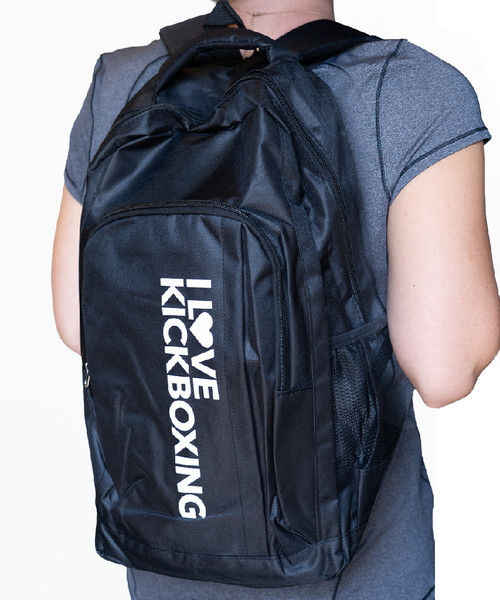 A person wearing a black backpack with a white I Love Kickboxing logo running vertically down the large front pocket